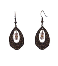 Load image into Gallery viewer, Warm gold shimmer behind antique bronze lace. The feeling of late afternoon light, held in an earring.
The Golden Dew Teardrop Filigree Earrings pair a gold shimmer polymer clay backing with an intricate antique bronze brass teardrop filigree frame. Inside the open cutout, a faceted bronzy glass bead catches and scatters the light with every turn of your head.
Gold on bronze. Shimmer on texture. Warmth on warmth. Rich, luminous, and completely one-of-a-kind.
