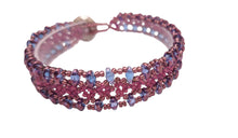 Load image into Gallery viewer, Soft does not mean subtle. Mauve is the color of quiet confidence.
Laced in Mauve is the piece you reach for when you want to feel polished without trying too hard. It layers beautifully, stands alone effortlessly, and goes from a client lunch to a sunset walk without missing a beat.
 Handcrafted by Veronica of River Jewels, this bracelet is woven in a lace-inspired pattern using fine seed beads and two-hole duo beads in a warm, dusty mauve tone. A Swarovski Crystal Button to finish. One-of-a-kind. 
